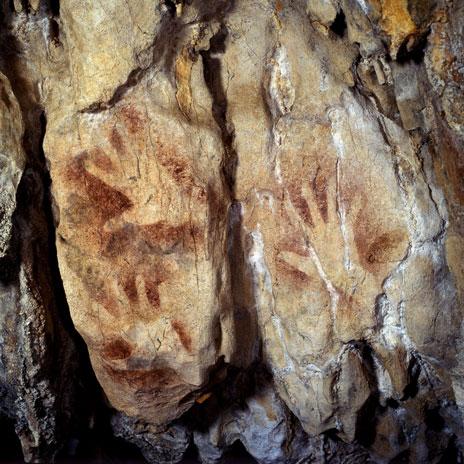 Pinturas rupestres de manos sobre la pared de una cueva